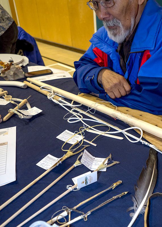 Artisans from around the region were in attendance at the 2018 Kivalliq Trade show to sell their products and attend seminars to help them promote their products. Here, Honore Aglukka from Naujaat looks over his collection of hunting tools. (PHOTO COURTESY OF THE 2018 KIVALLIQ TRADE SHOW)