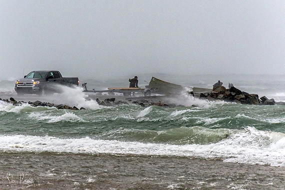 A man in Inukjuak tries to pull in his boat on Thursday, Oct. 4  as high winds create choppy waters at the Nunavik community's old dock. The same weather system that struck south Baffin Island, ripping metal roofs from buildings in Iqaluit, also hit communities in Nunavik’s Ungava Bay and Hudson Bay from the evening of Oct. 4 until the following morning. Wind warnings remain in effect for Aupaluk, Inukjuak, Kangiqsualujjuaq, Puvirnituq, Taisujaq and Umiujaq. (PHOTO BY SYLVAIN PARADIS) 