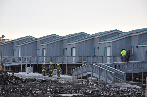 Iqaluit firefighters assess the condition of elders' housing units Nov. 9, a day after a fire destroyed Northmart's warehouse, just metres away. (PHOTO BY SARAH ROGERS)