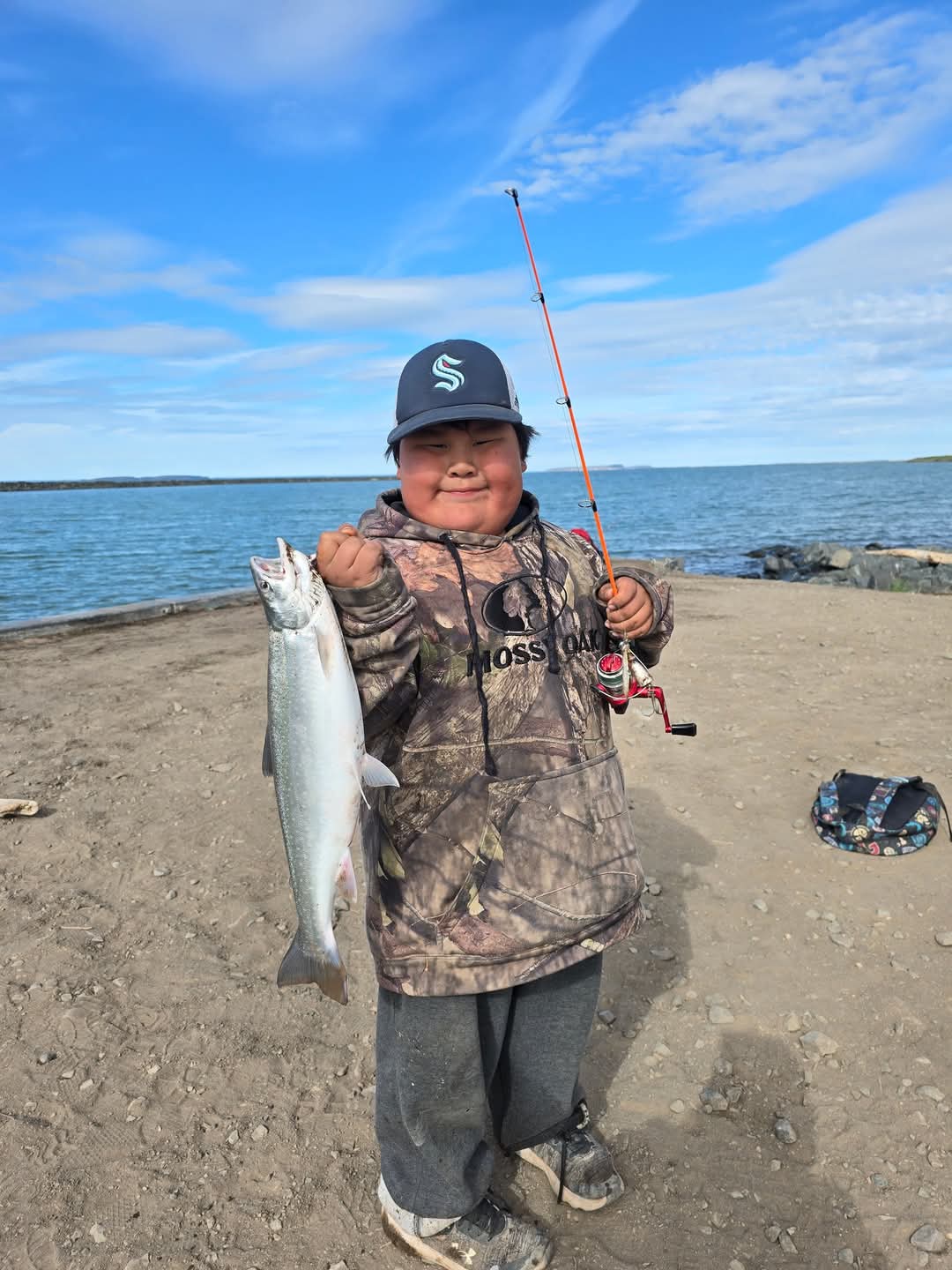 Jobe Kukilukak, 6, catches his first Arctic char of the summer season on the shore of Coronation Gulf in Kugluktuk over the weekend. An experienced fisherman, Kukilukak became the master of the rod when he was three. His mom, Papak Miyok, is planning to make some fish chowder with the footlong catch. (Photo courtesy of Christine Kuliktana)