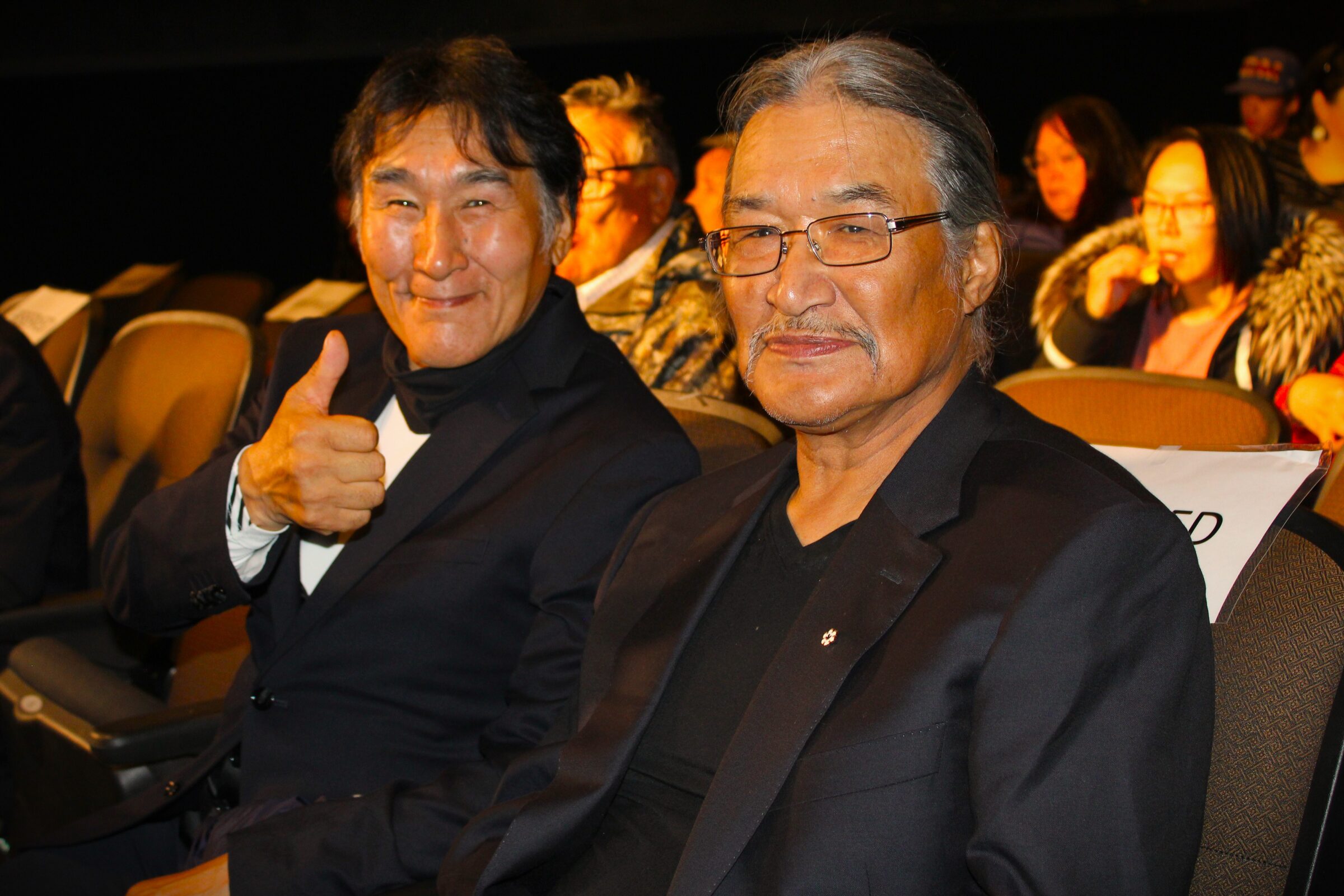 Acting coach Natar Ungalaaq, left, and director Zacharias Kunuk sit in the Astro Theatre in Iqaluit Friday as they await a free screening of Kunuk’s film “Uiksaringitara (The Wrong Husband).” The filmmaker and actors stayed for a question-and-answer session with the audience. The film was named best Canadian feature film at the Toronto International Film Festival this month. (Photo by Daron Letts)