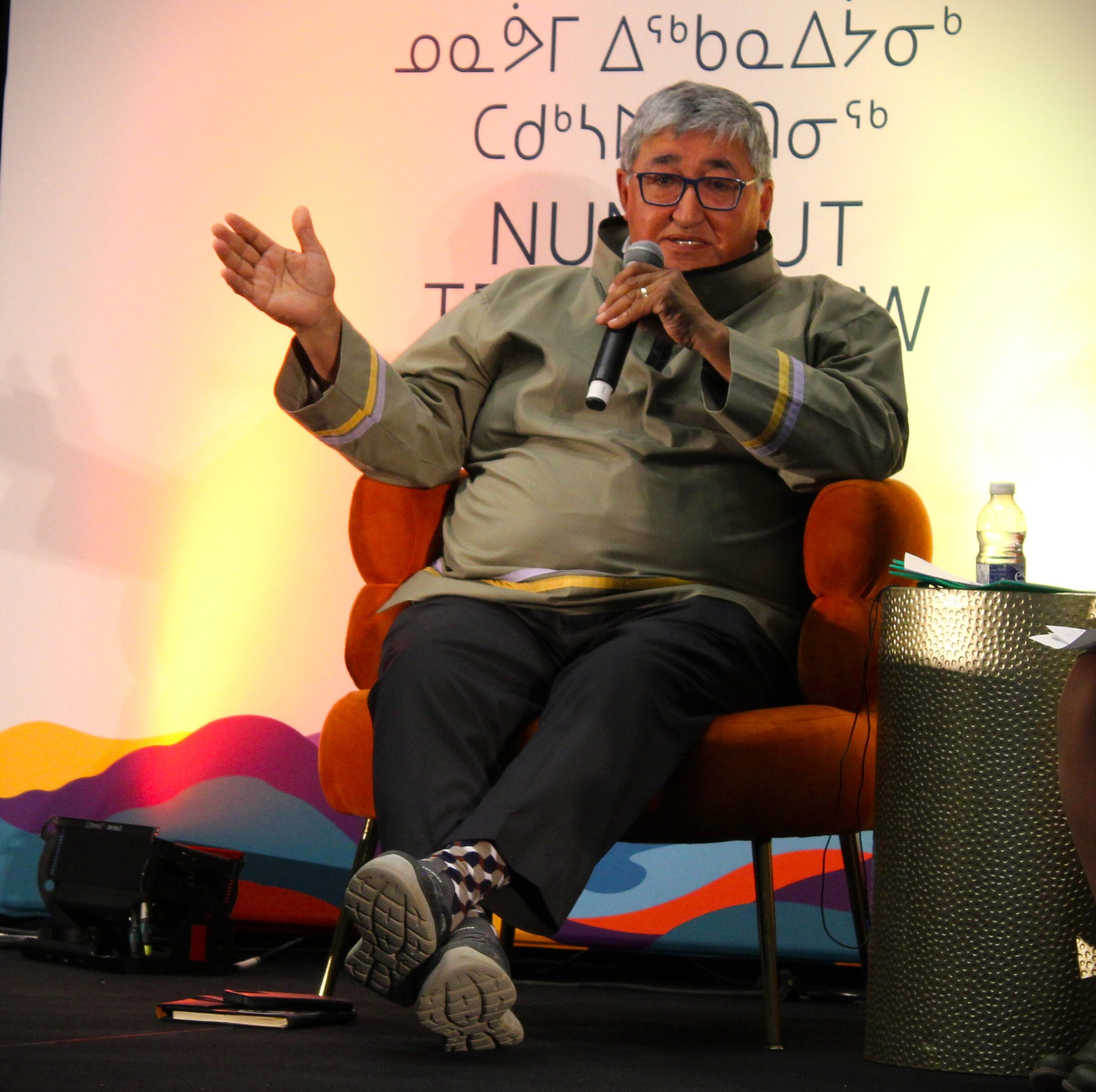Paul Irngaut, vice-president of Nunavut Tunngavik Inc., speaks at the Nunavut Trade Show in Iqaluit on Tuesday morning. His talk was billed as a fireside chat about Nunavut’s role in Canada’s economic future. “If you don’t have healthy communities, you can’t really have clear sovereignty and security in the North,” he said. (Photo by Daron Letts) 
