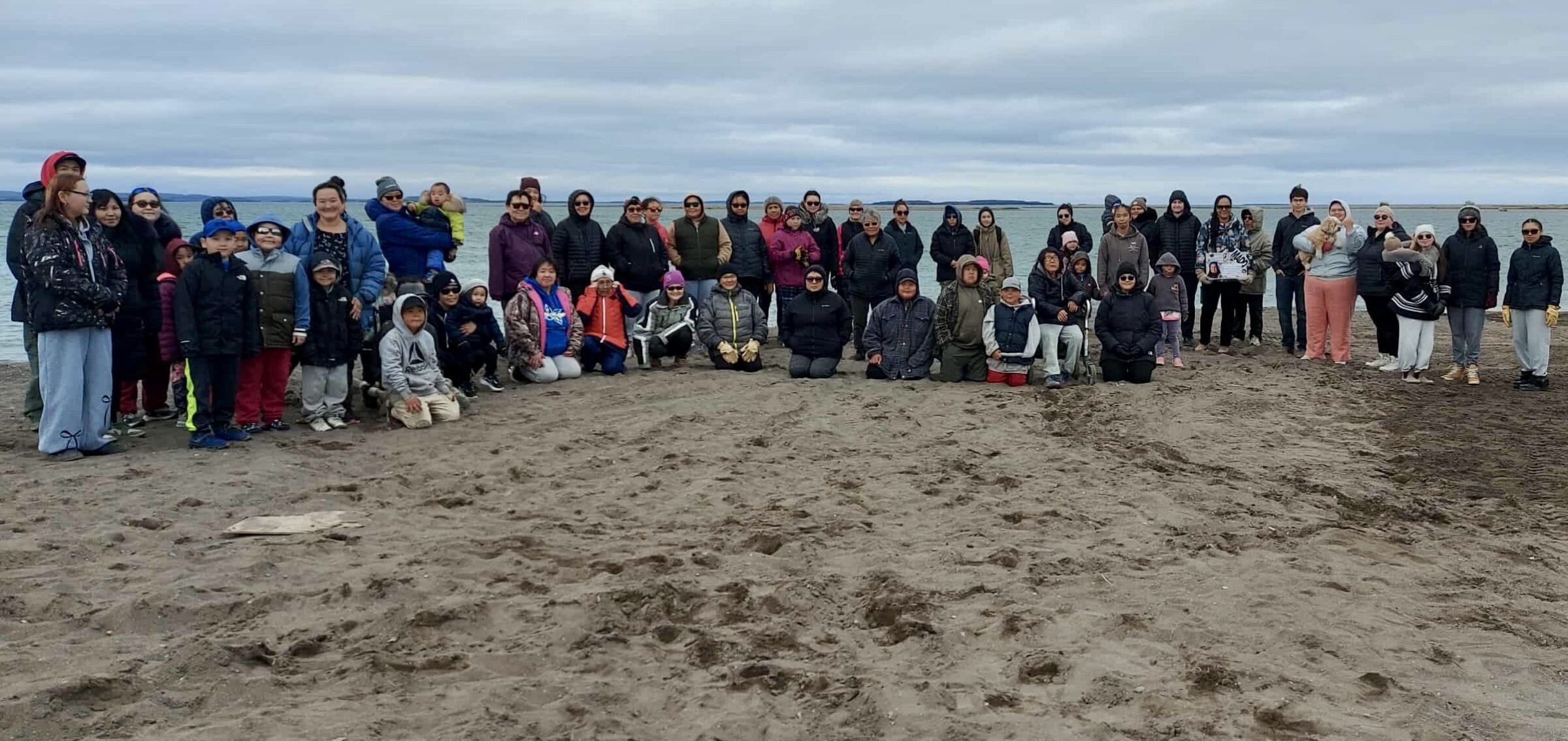 About 60 people gather on the shore of Coronation Gulf in Kugluktuk after Saturday’s walk in memory of Angella Rose Kuliktana, who died in a drunk-driving crash 13 years ago. Some participants carried posters with Kuliktana’s image and played her favourite song, “Safe and Sound,” by Capital Cities. Angella Rose’s mother Christine Kuliktana organized the walk and said she hopes it will help raise awareness about impaired driving. (Photo courtesy of Christine Kuliktana)