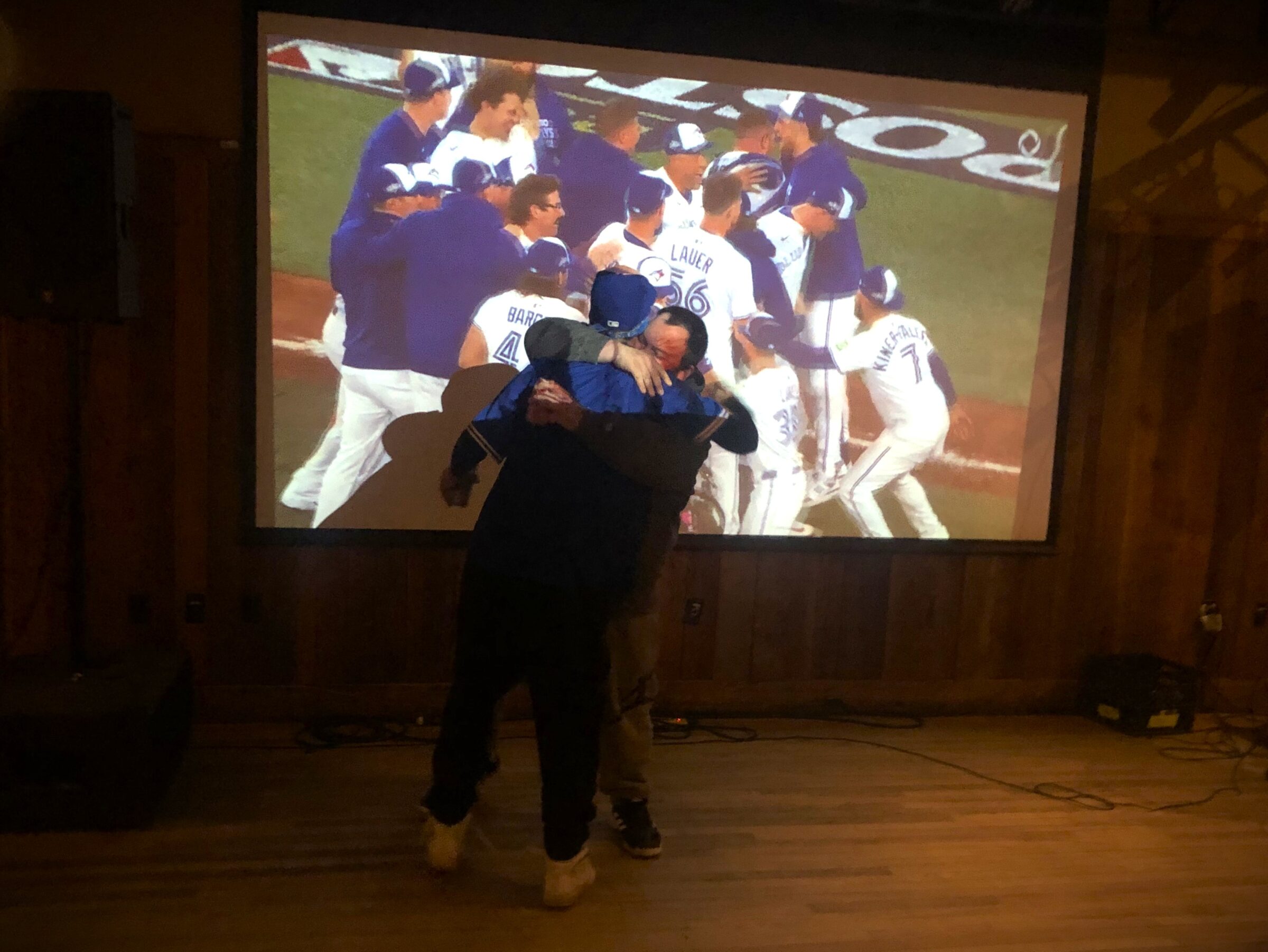 Randy Saint, left, and C.J. Smith of Edmonton embrace at the Storehouse bar in Iqaluit after the Toronto Blue Jays won Game 7 of the American League Championship Series. The Jays defeated the Seattle Mariners 4-3 in the final game of the series to win the American League pennant and advance to the World Series against the Los Angeles Dodgers. (Photo by Daron Letts)