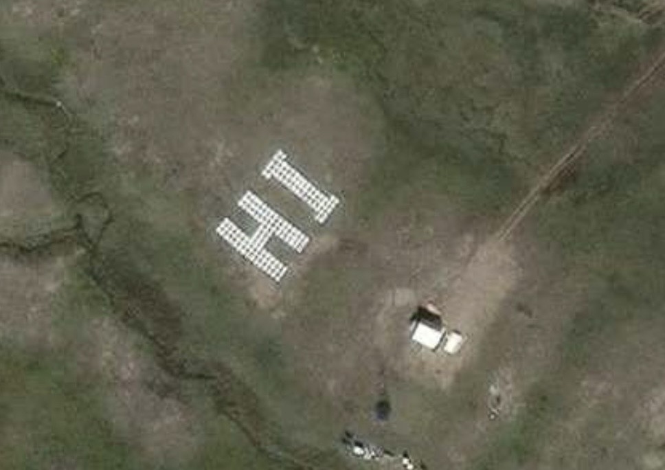 A message pops out from the tundra about 3.5 kilometres from Baker Lake on Oct. 7. Freddie Oovayuk used 152 wooden pallets painted white to spell the greeting near his cabin. The message, which took three weeks to create, briefly appeared on the flight-tracking app FlightRadar24 and Apple Maps before it was blurred. He hopes the sign will eventually show up on Google Earth. (Photo courtesy of Freddie Oovayuk/FlightRadar24) 