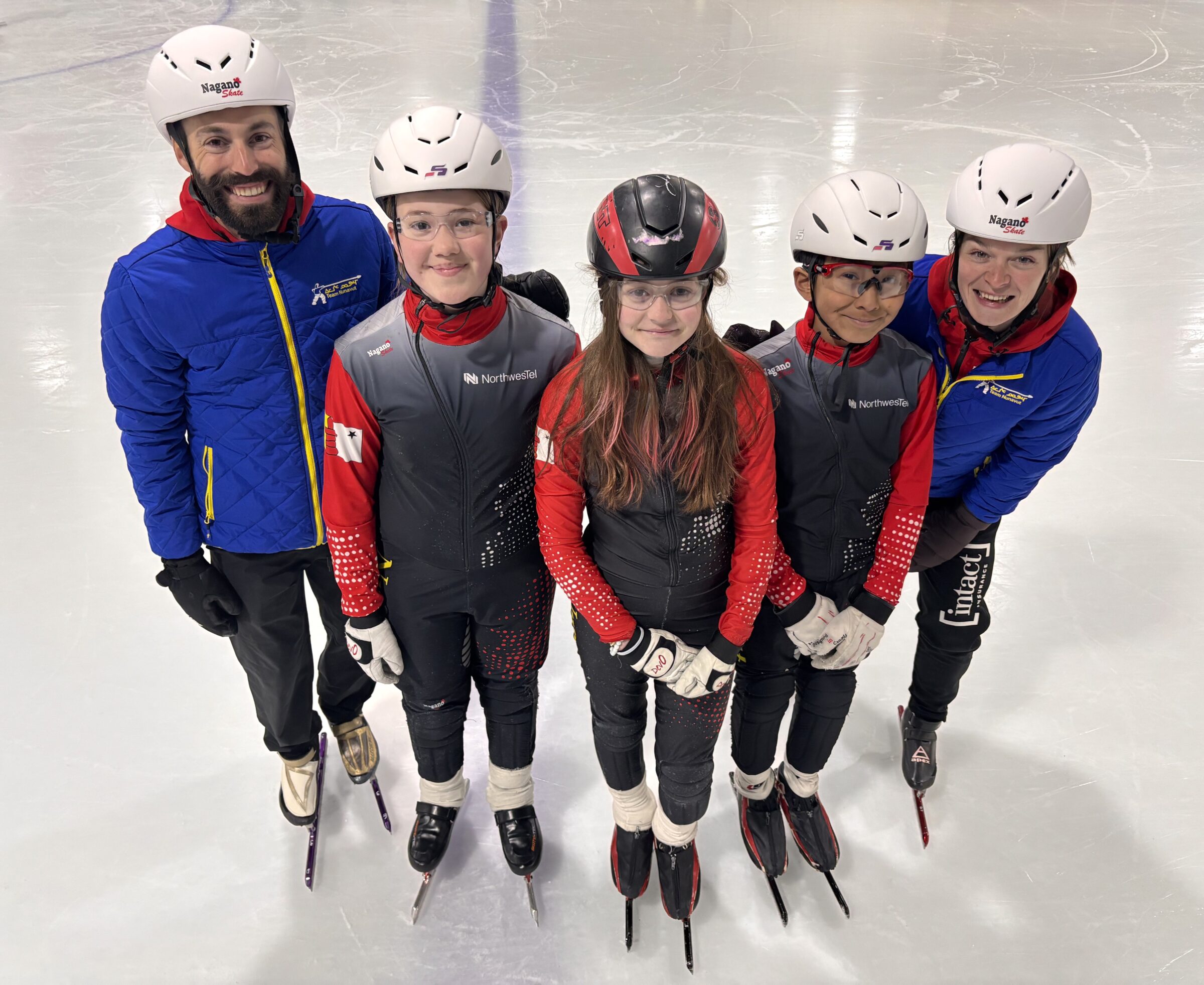 Five-time Olympic speedskater Stephen Dubois, left, and six-time Olympic speedskater Kim Boutin, right, meet with young skaters at Iqaluit’s Arctic Winter Games Arena on Wednesday. They are pictured with 12-year-olds Viivi Morrison-Mike, Hannah Didham and Eliyah Laird. The event was part of Toonik Tyme, which continues through Monday. (Photo by Daron Letts)