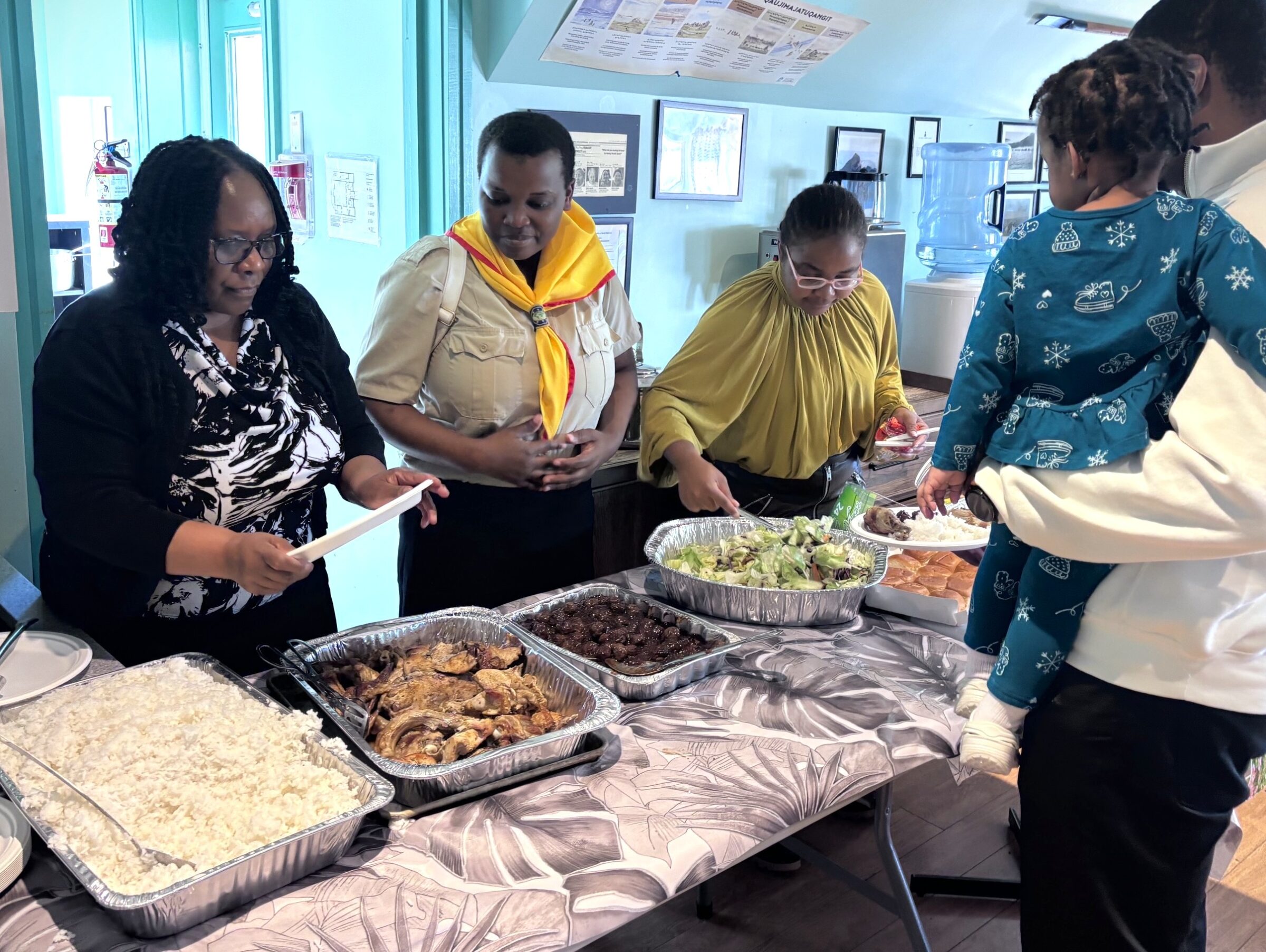 From left, volunteers Keswa Tembeka, Night Bakunzi and Sharon Poshai dish out free lunch at the Elders Qammaq in Iqaluit on Saturday. Dozens of residents took part in the event, organized by Nunavut Seventh Day Adventists. (Photo by Daron Letts)