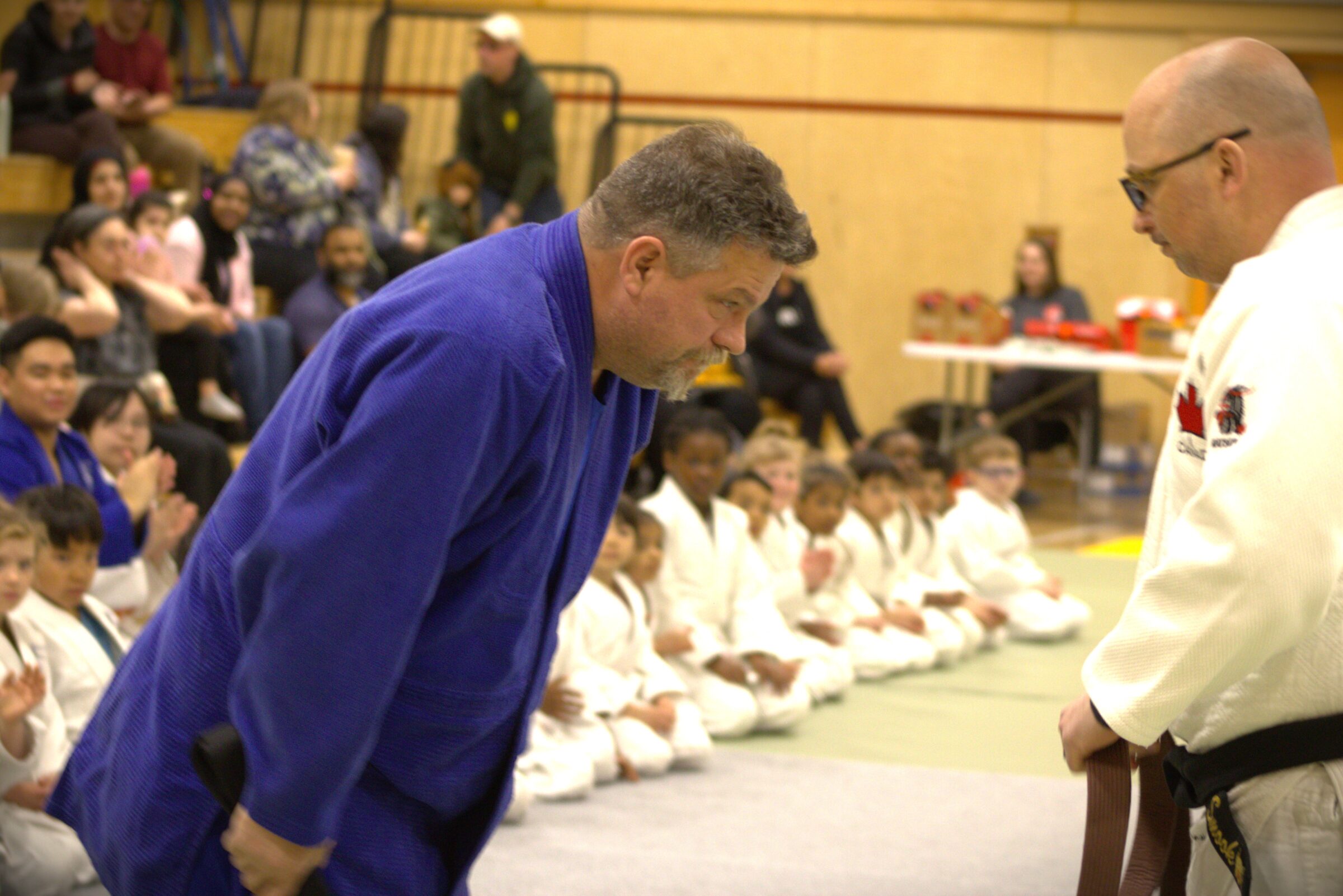 Andrew Keim, a Judo Nunavut coach and volunteer for two decades, receives his black belt from fellow coach Michael Smook at Aqsarniit middle school in Iqaluit on Saturday. The ceremony was part of the organization’s year-end tournament. (Photo by Daron Letts)