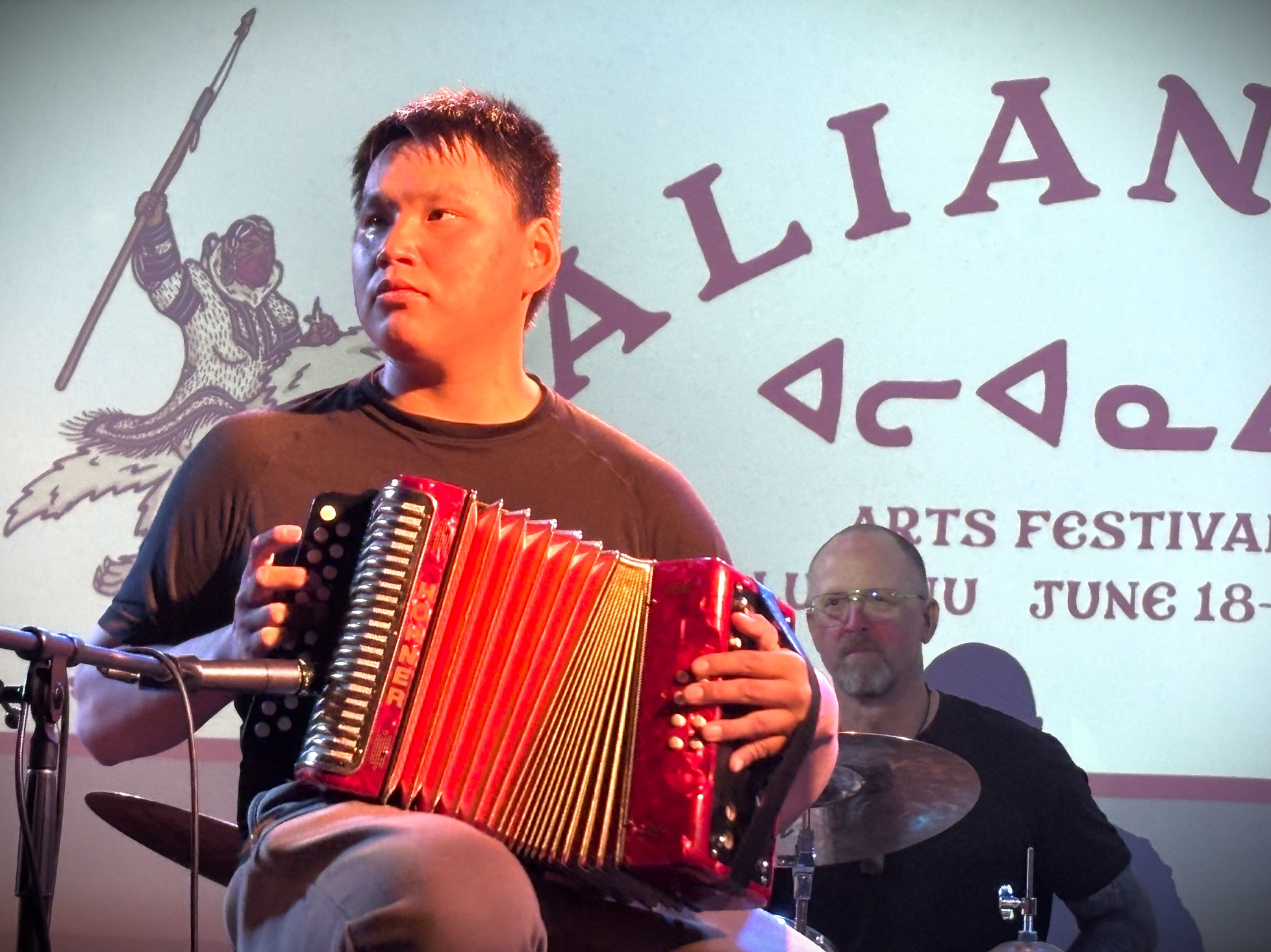 Hip hop artist Jacob Okatsiak of Arviat brings out an accordion Thursday evening at the Storehouse Bar in Iqaluit, during the Alianait Arts Festival jam. He is backed by drummer Blair Williams. The festival continues through Sunday. (Photo by Daron Letts)